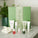 The Advanced Glow Facial - active skincare collection by Tropic. A large green festive gift set box with a full routine displayed in front: Smoothing Cleanser, Hydrating Cleanser, Skin Feast moisturiser, Juicy Greens essence, and three serum drops — Glow Berry, Fruit Peel, and Super Greens.
